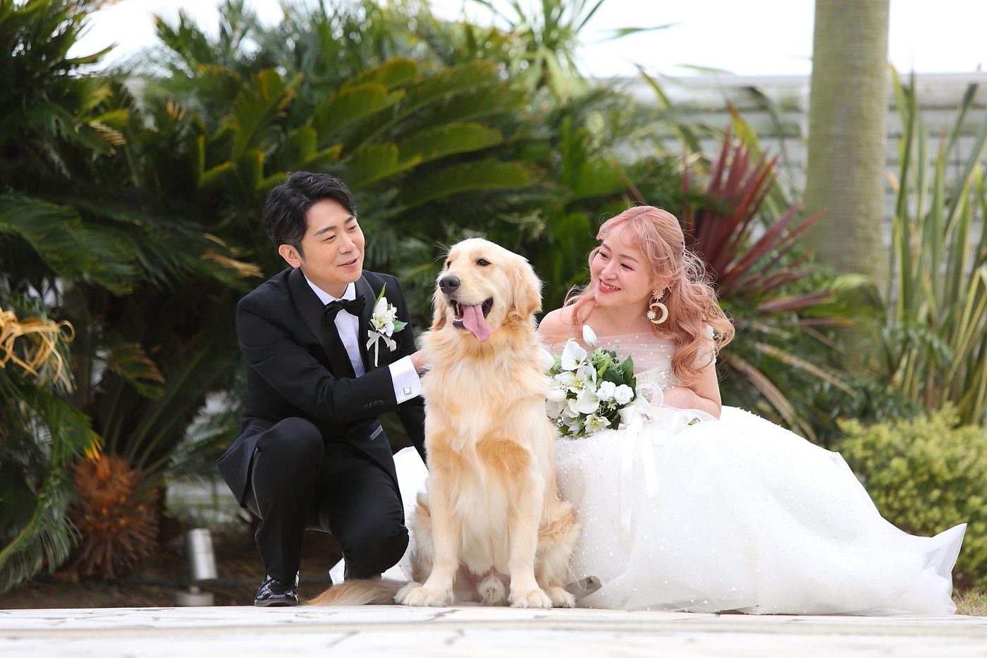 愛犬を真ん中に、ガーデンで笑う新郎新婦。愛犬との事例へ